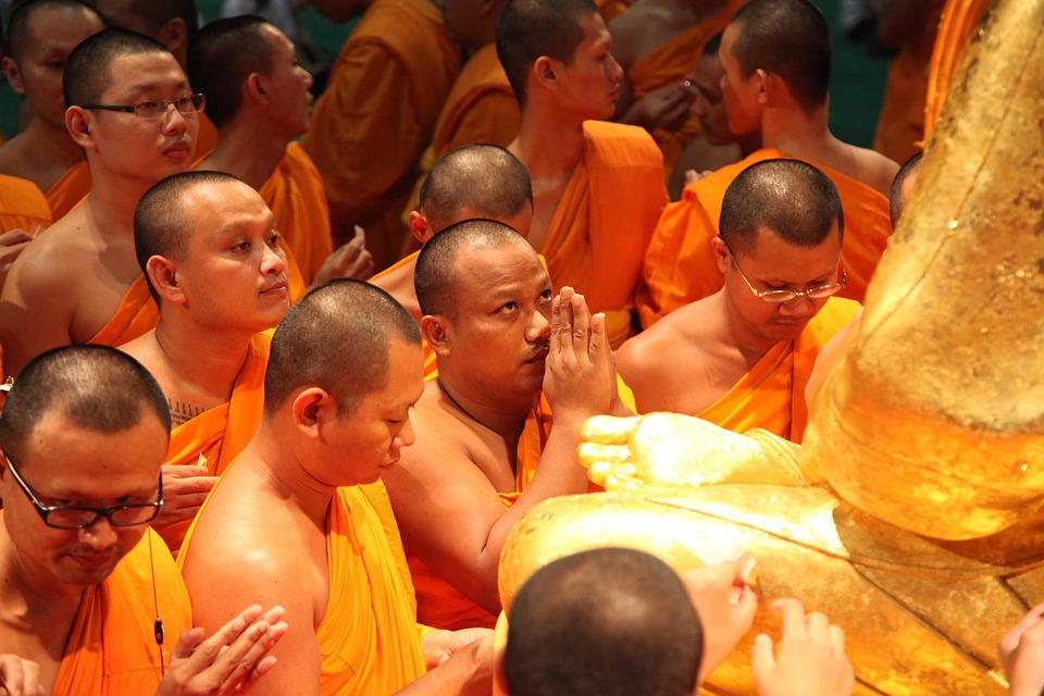 Monks paying respect at the golden statue of Phramongkolthepmuni